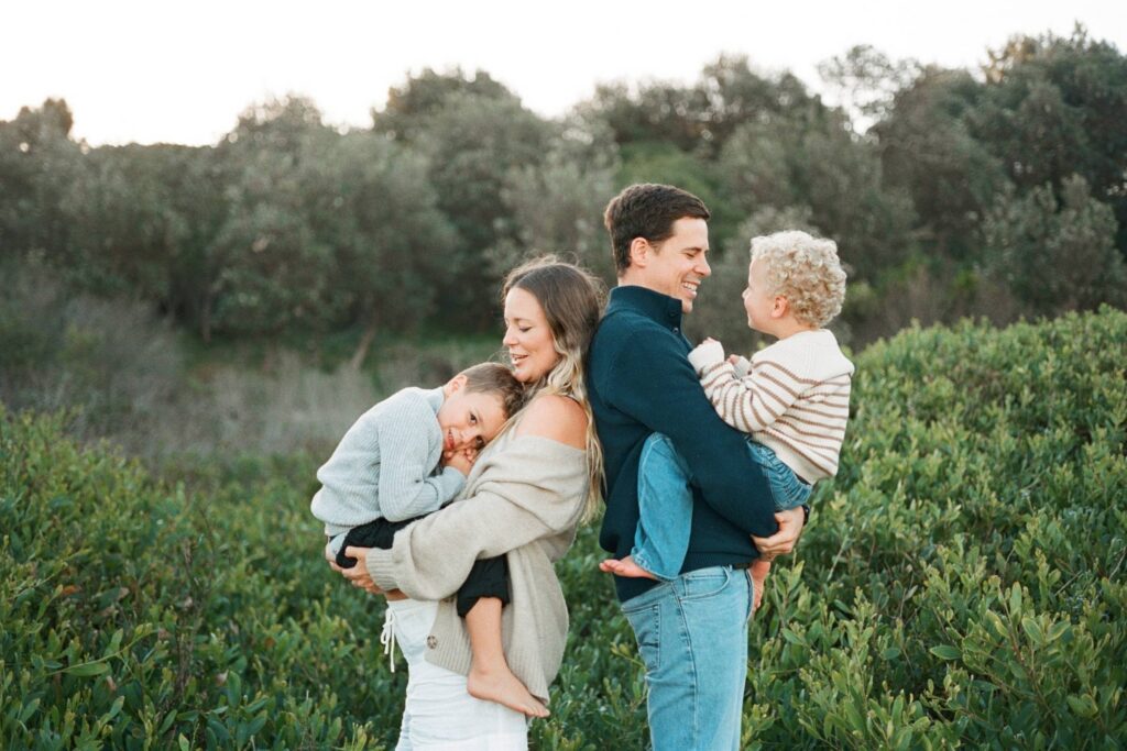 Child holding mums hand during a natural outdoor family photoshoot in Sydney