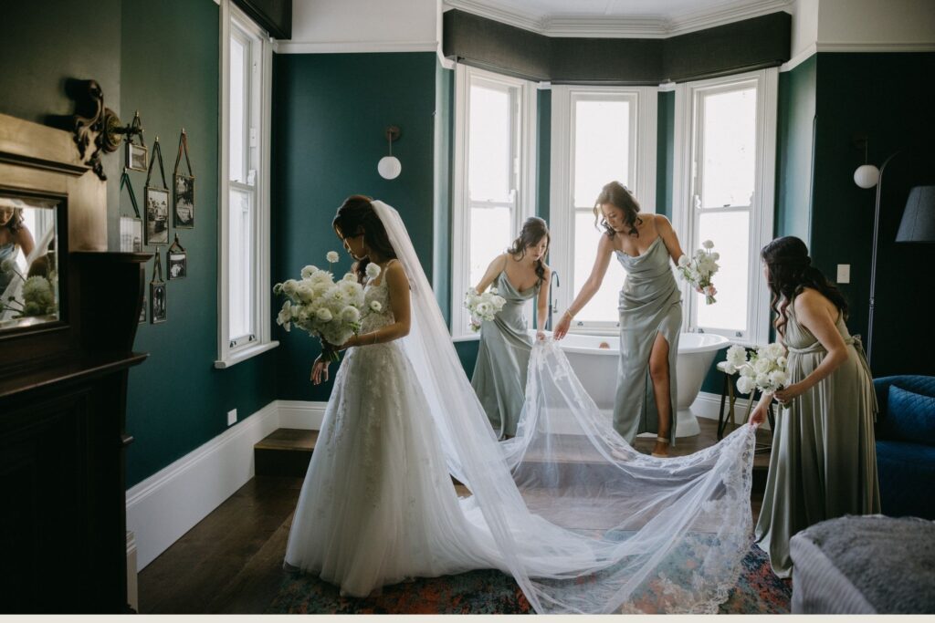 Bride having her veil arranged by a bridesmaid during wedding morning preparations — documentary wedding photography Sydney by Tealily Photography