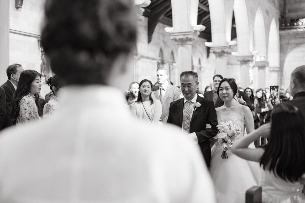 Black and white documentary photograph of a wedding ceremony processional — natural wedding photography Sydney by Tealily Photography