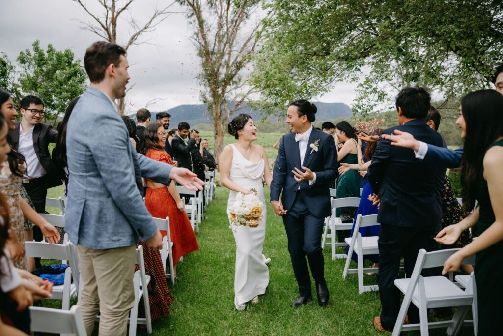 Colourful outdoor wedding ceremony with guests celebrating — documentary wedding photographer Sydney by Tealily Photography