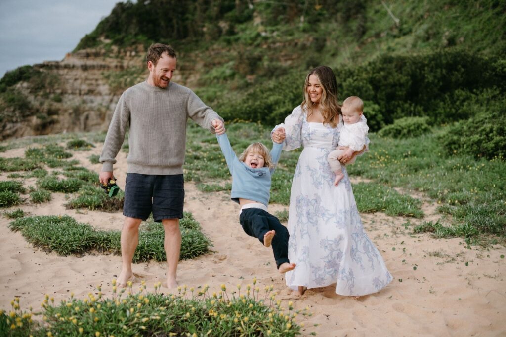 A family of four enjoying a Sydney beach for a relaxed family sessions with their young boy and baby in arms