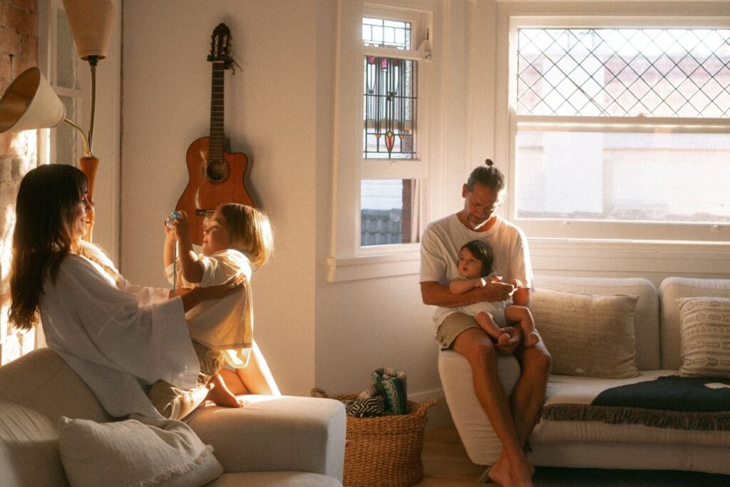A family with a baby and a young boy photographed in their home in Manly with the morning light streaming through