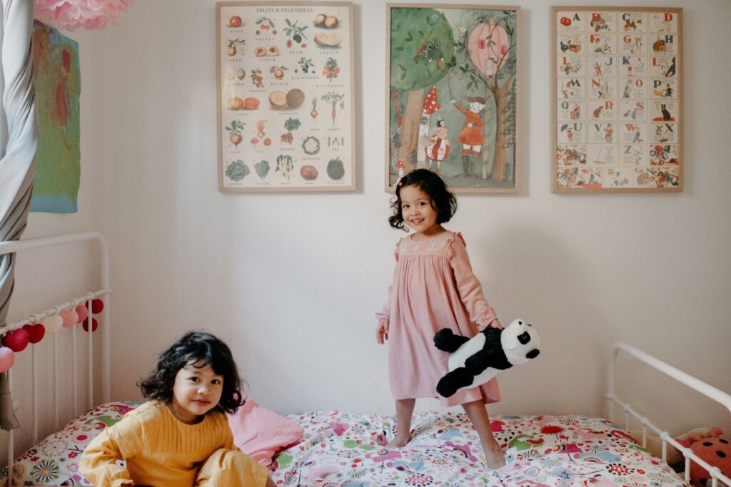 a colourful bedroom with twin girls in soft winter dresses