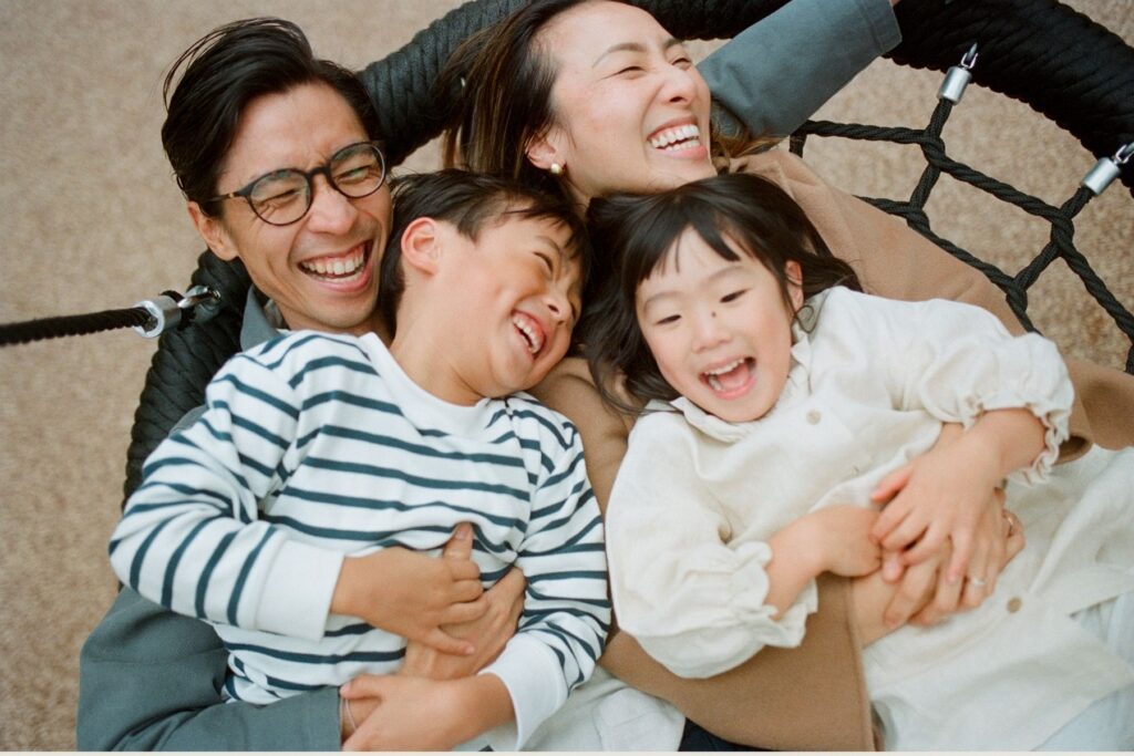 joyful family of four cuddled together in warm knits and layers